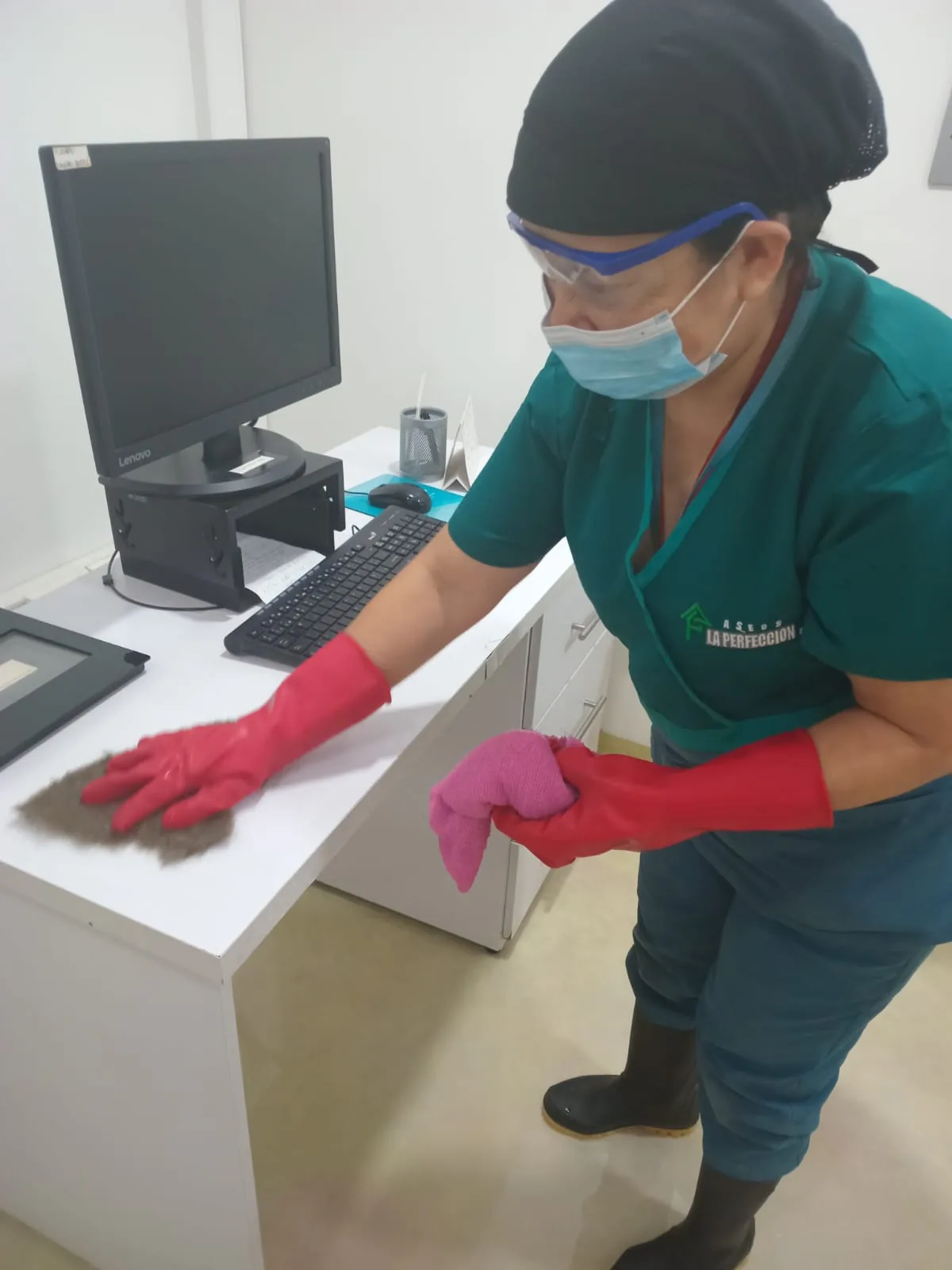 Operaria de aseo en labores de oficina, con elementos de protección personal